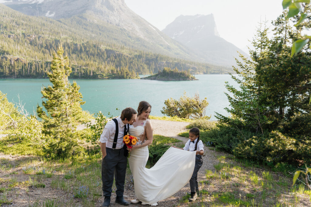 Aiden helping lay out Bree’s dress on the rocks during their elopement portraits.