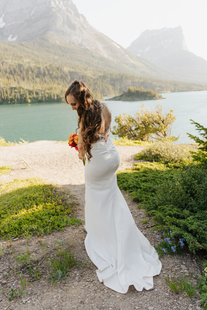 The bride looks back at her train in the shade at Sun Point.