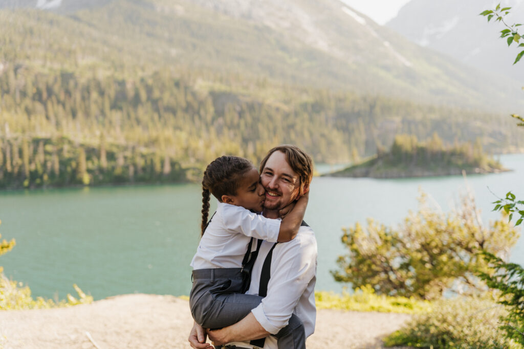 Will holding Aiden as he gives Will a cheek kiss in the shade at Sun Point.