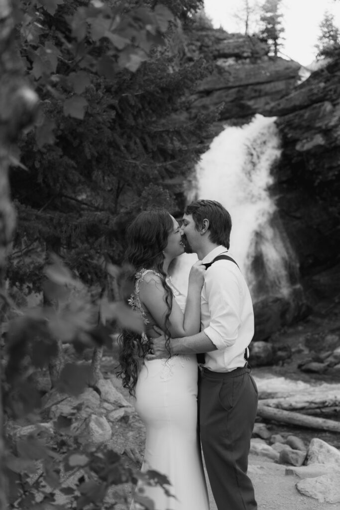 Bride and groom exploring the Baring Falls after eloping at Sun Point in Glacier National Park.
