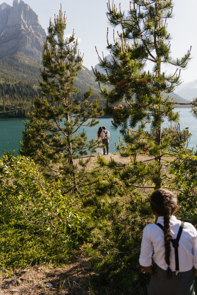 Bride and groom's child shows photographer where to shoot during elopement in Glacier National Park.