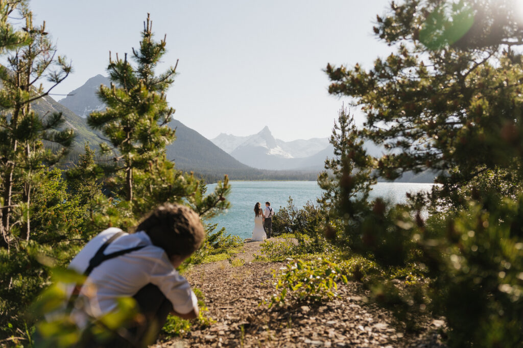 Bride and groom's child shows photographer where to shoot during elopement in Glacier National Park.