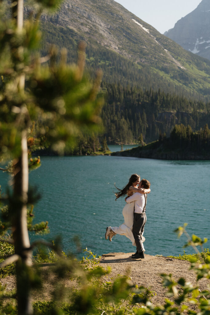 Bride and groom do a celebratory spin after eloping in Sun Point Glacier National Park.