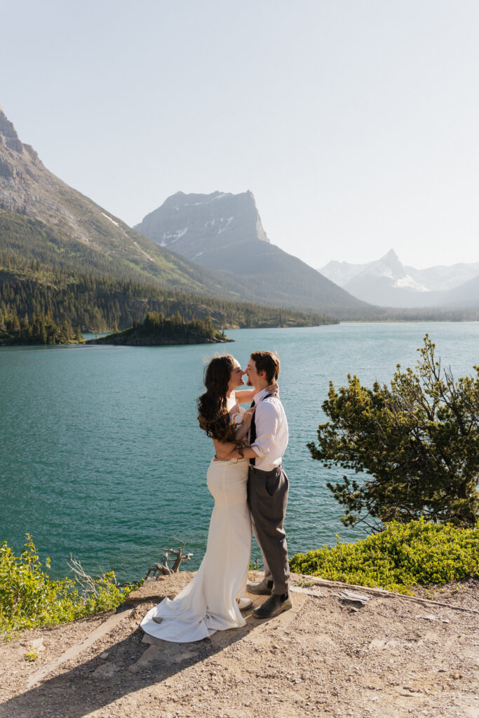 Bride and groom pose over the lake after eloping in Sun Point Glacier National Park.