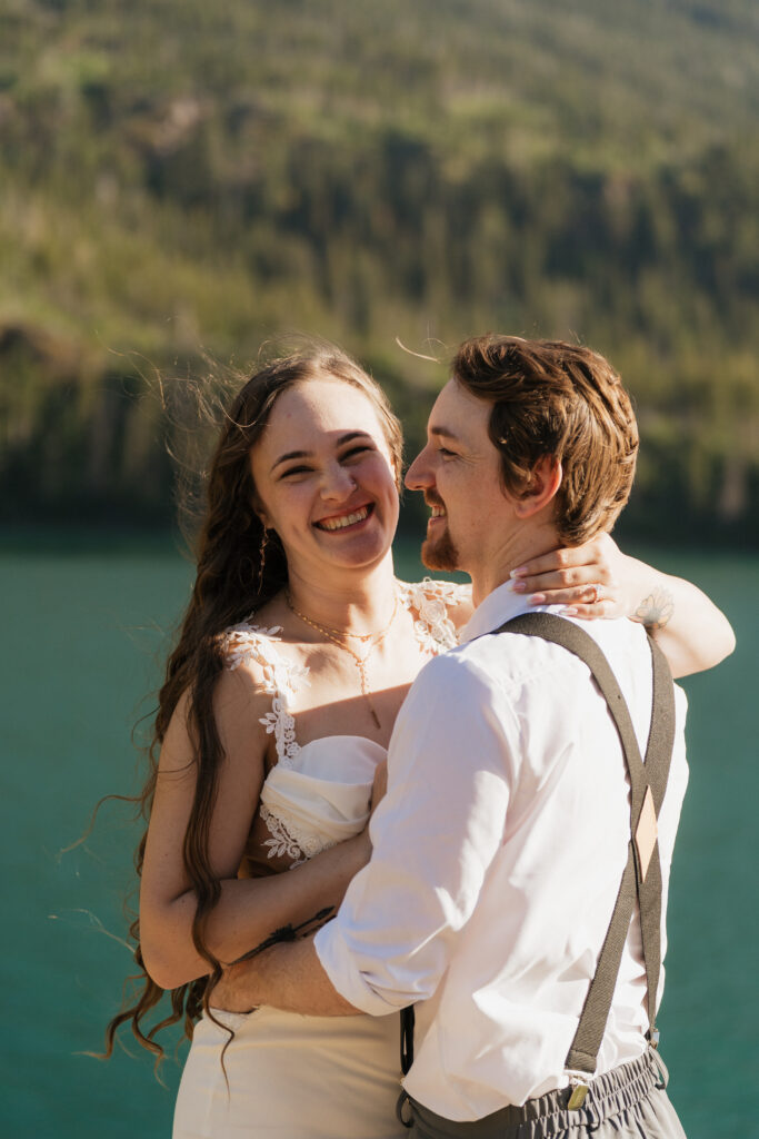 Bride and groom laugh at the camera after eloping in Sun Point Glacier National Park.