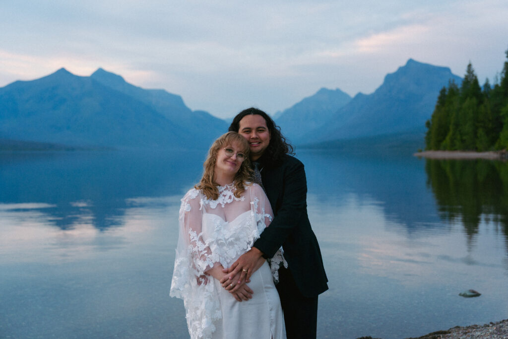 Couple poses in Lake McDonald after elopement in Glacier National Park.