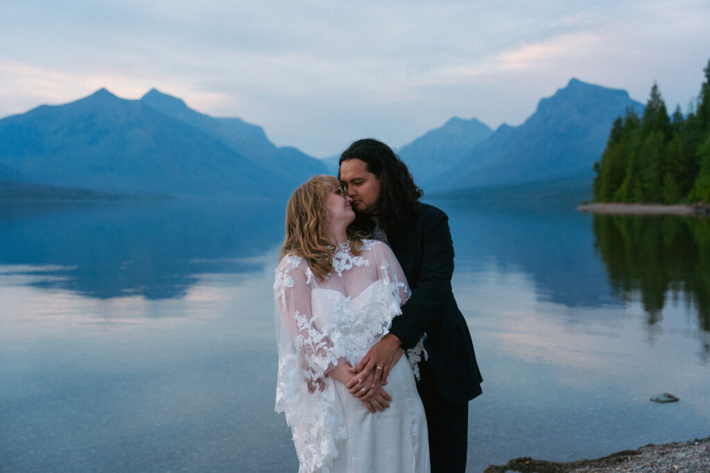 Couple kisses in Lake McDonald after elopement in Glacier National Park.