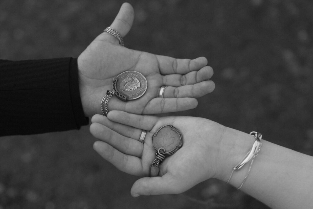 Couple shows off matching necklace in Lake McDonald after elopement in Glacier National Park.