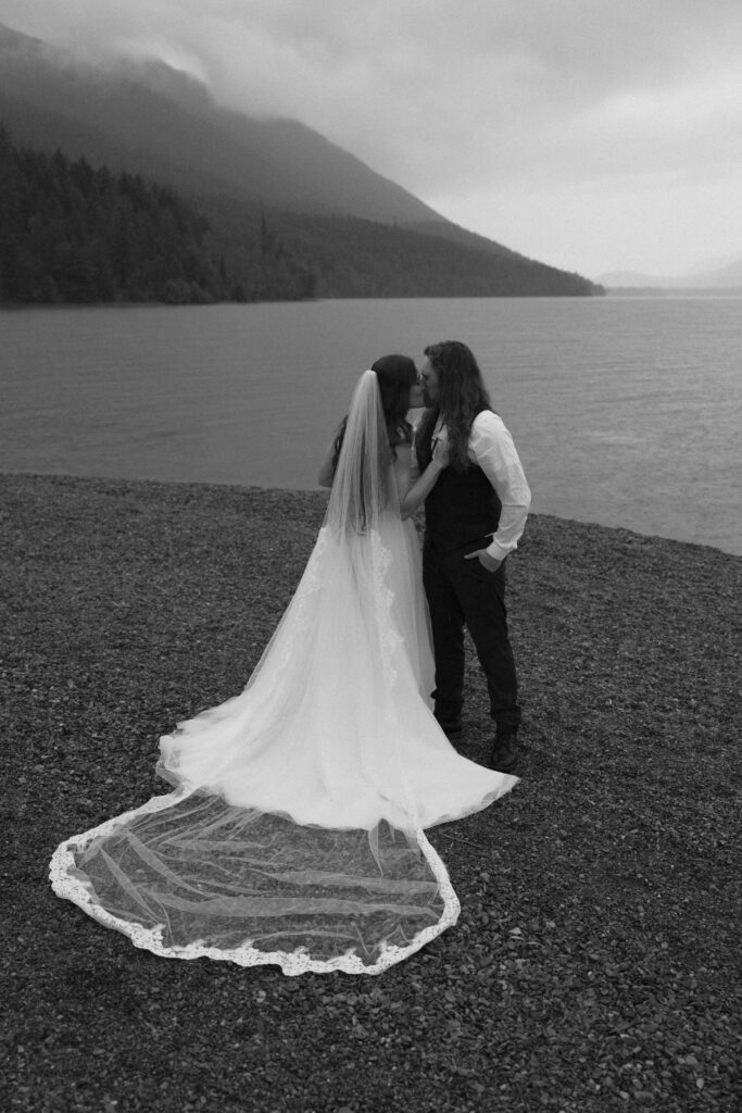 Couple kissing overlooking a foggy Lake McDonand in Glacier National Park