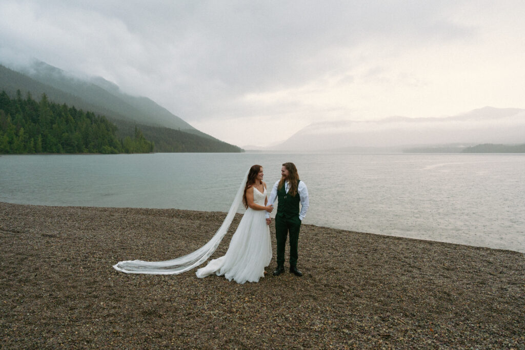 Couple walking together overlooking a foggy Lake McDonand in Glacier National Park