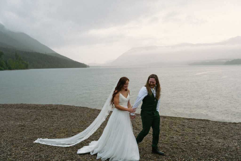Couple walking together overlooking a foggy Lake McDonand in Glacier National Park