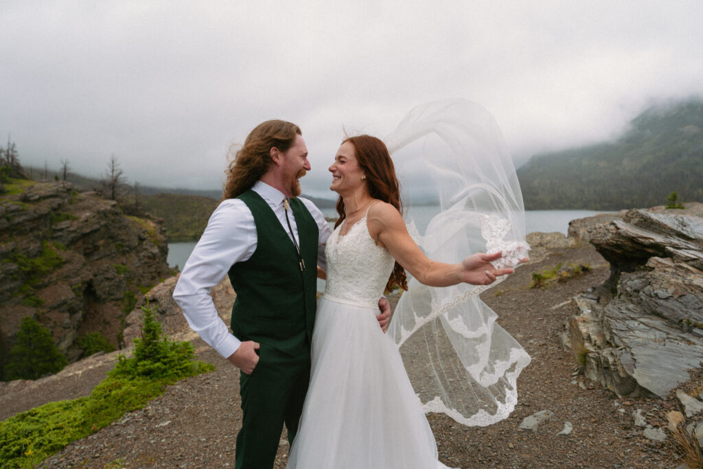 Couple laughing in the wind at Glacier National Park