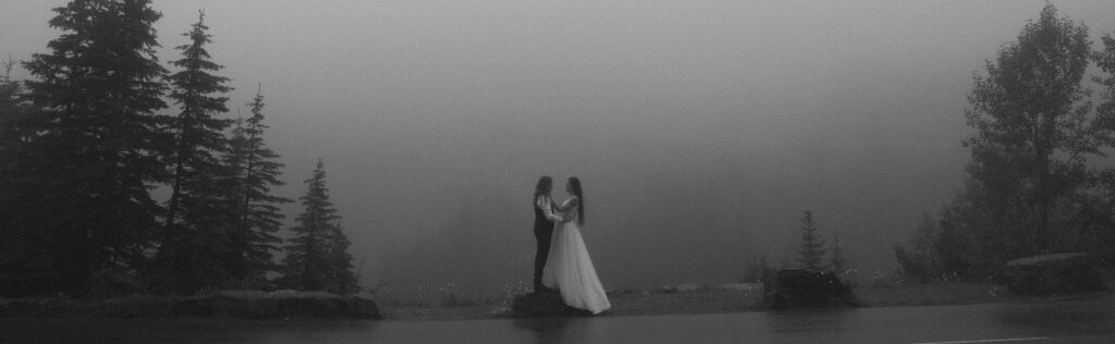 Couple posing at a foggy spot on Going to the Sun Road at Glacier National Park